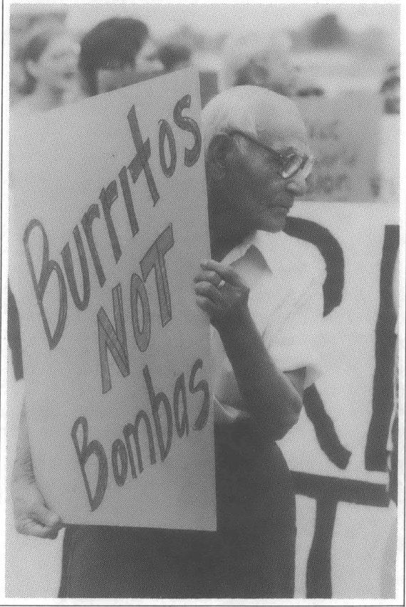 Old man carrying sign that reads "burritos not bombas"