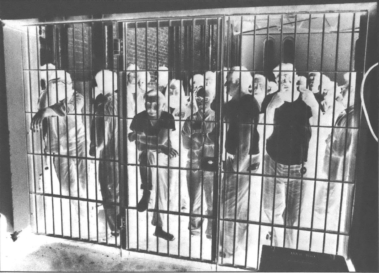 Photo negative of a group of people in a cell