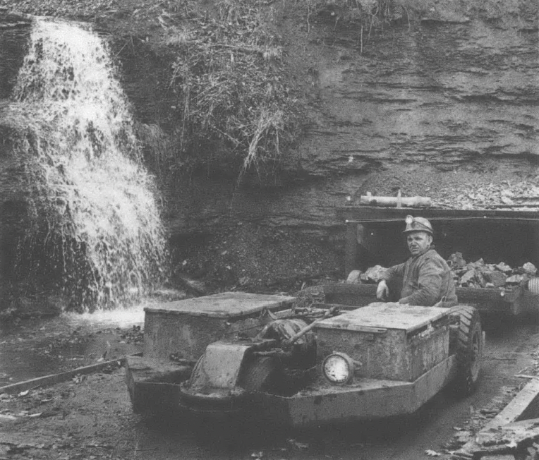 Photo of man on machinery rolling away from mountain or mine