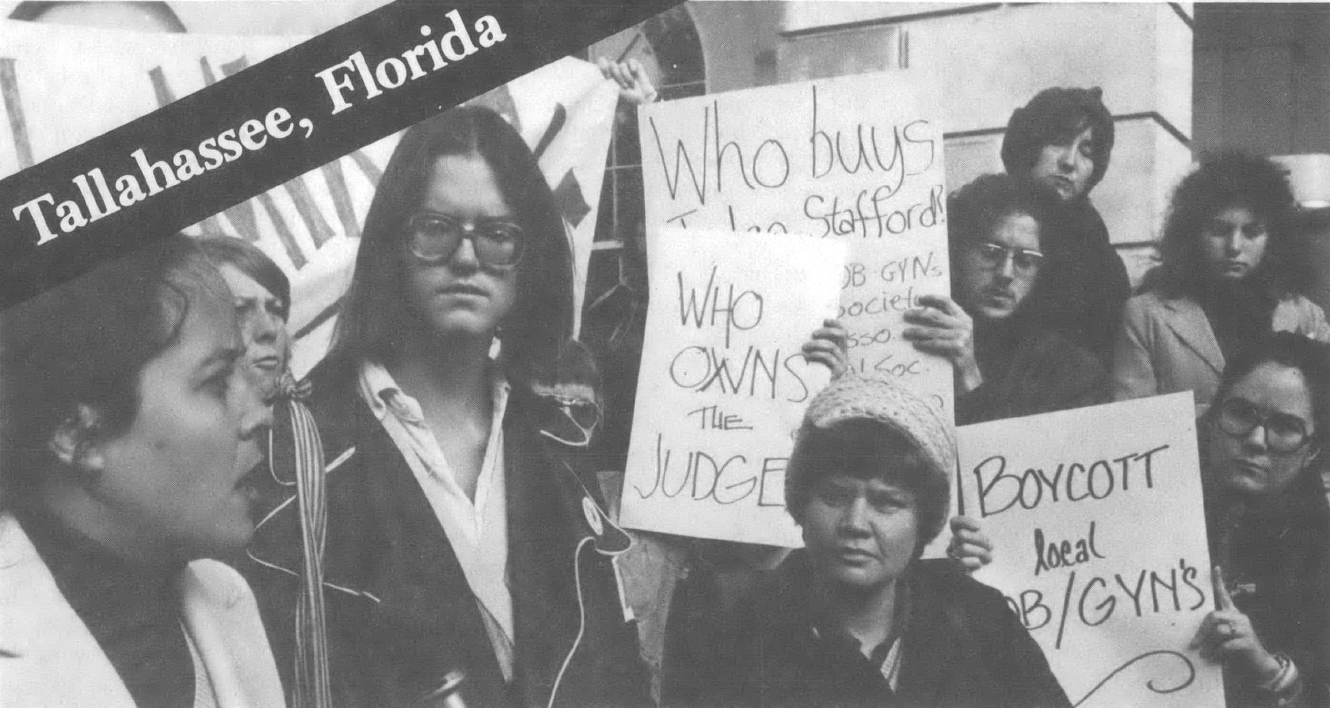 Black and white photo of people holding signs