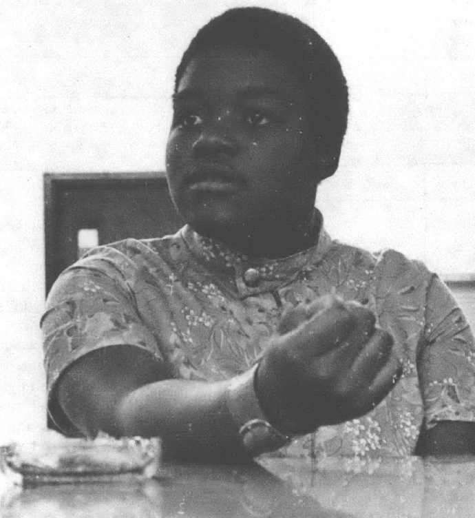 Black and white photo of Black woman sitting at table talking
