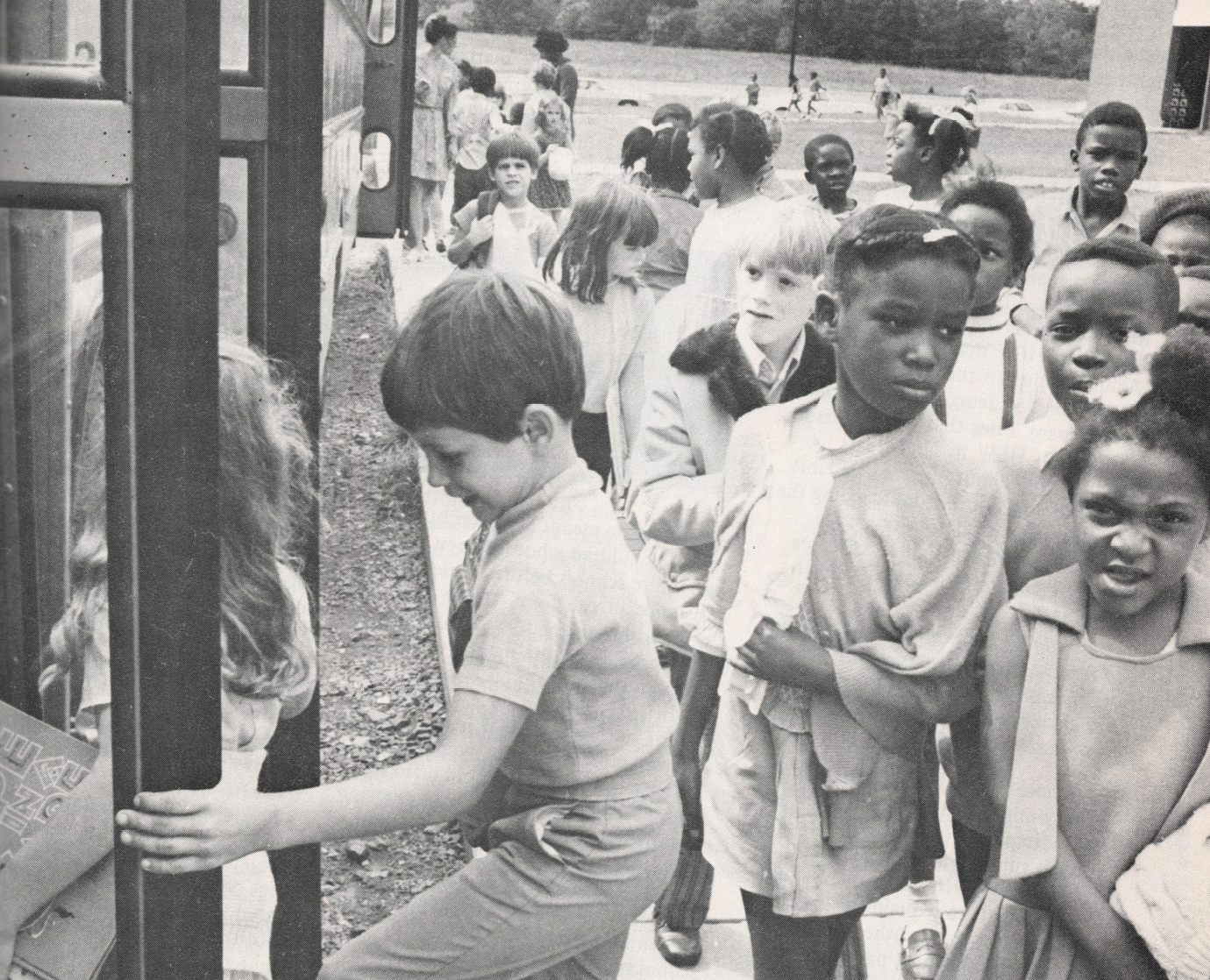 Black and white photo of students boarding a bus