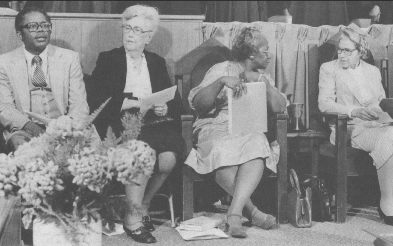 Black and white photo of Black leaders sitting on a stage 