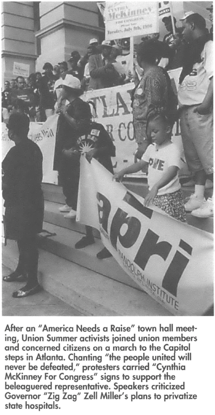 People holding signs on the steps of a building