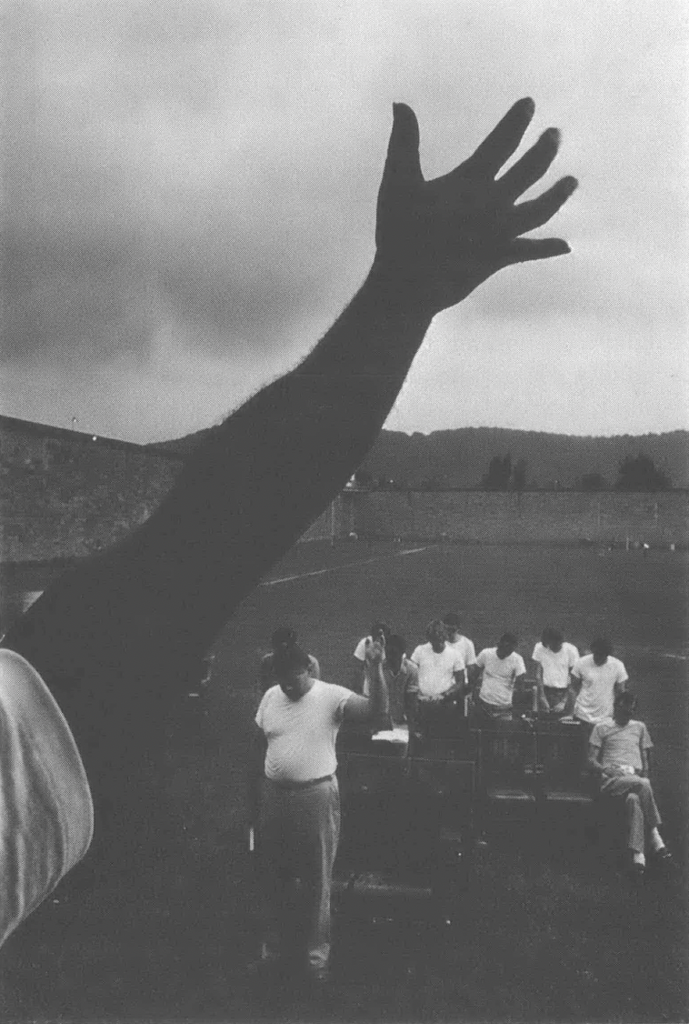 Black and white photo of group of people with outstretched arm in the forefront
