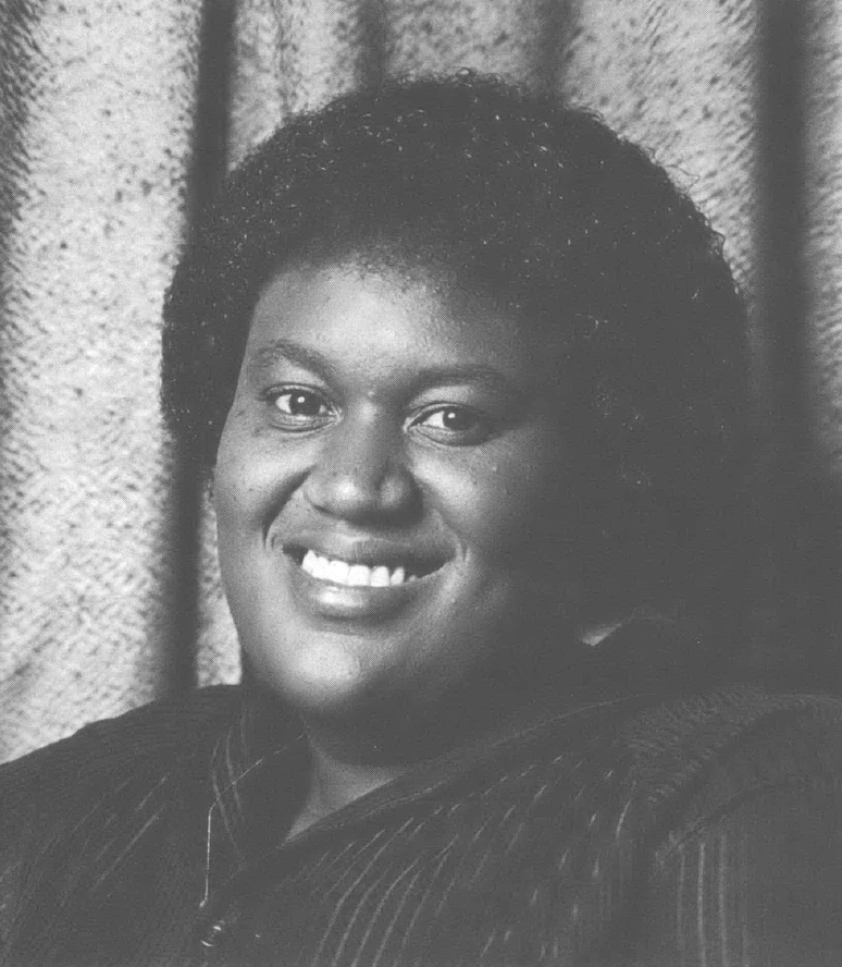 Black and white photo portrait of Black woman smiling at camera