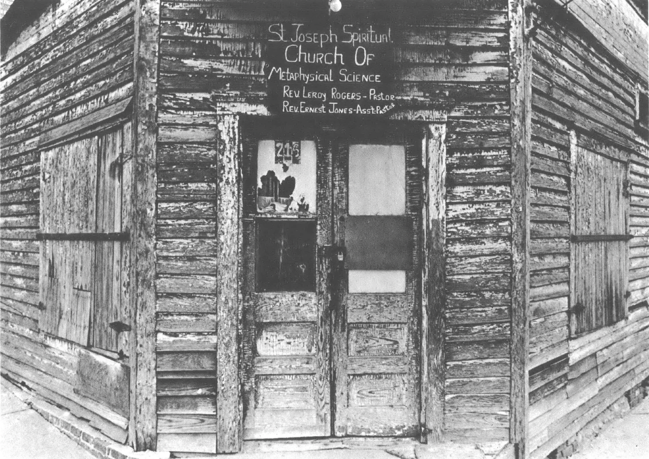 Black and white photo of a brick building on the corner of a street