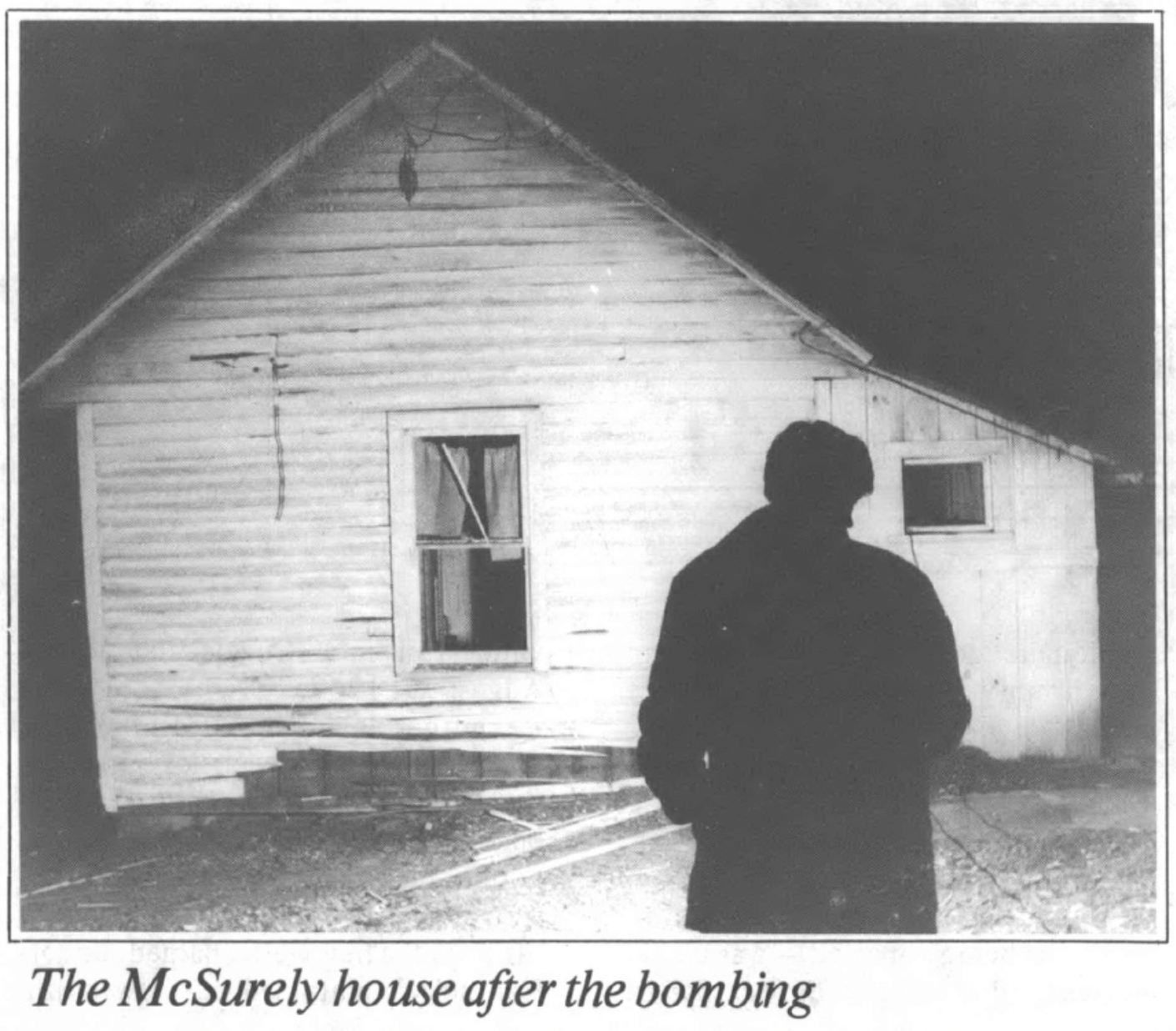 shadowed figure in front a bombed house