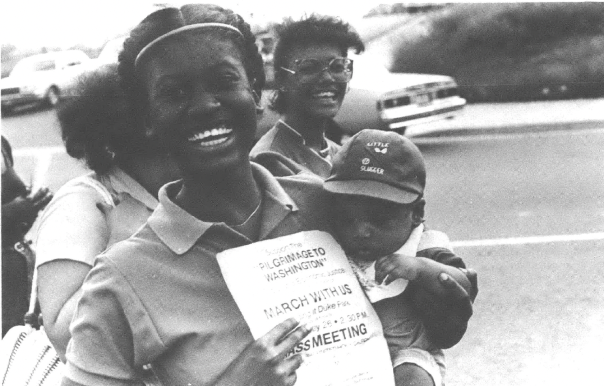 Woman holding baby and poster about the Carrollton-to-Washington March