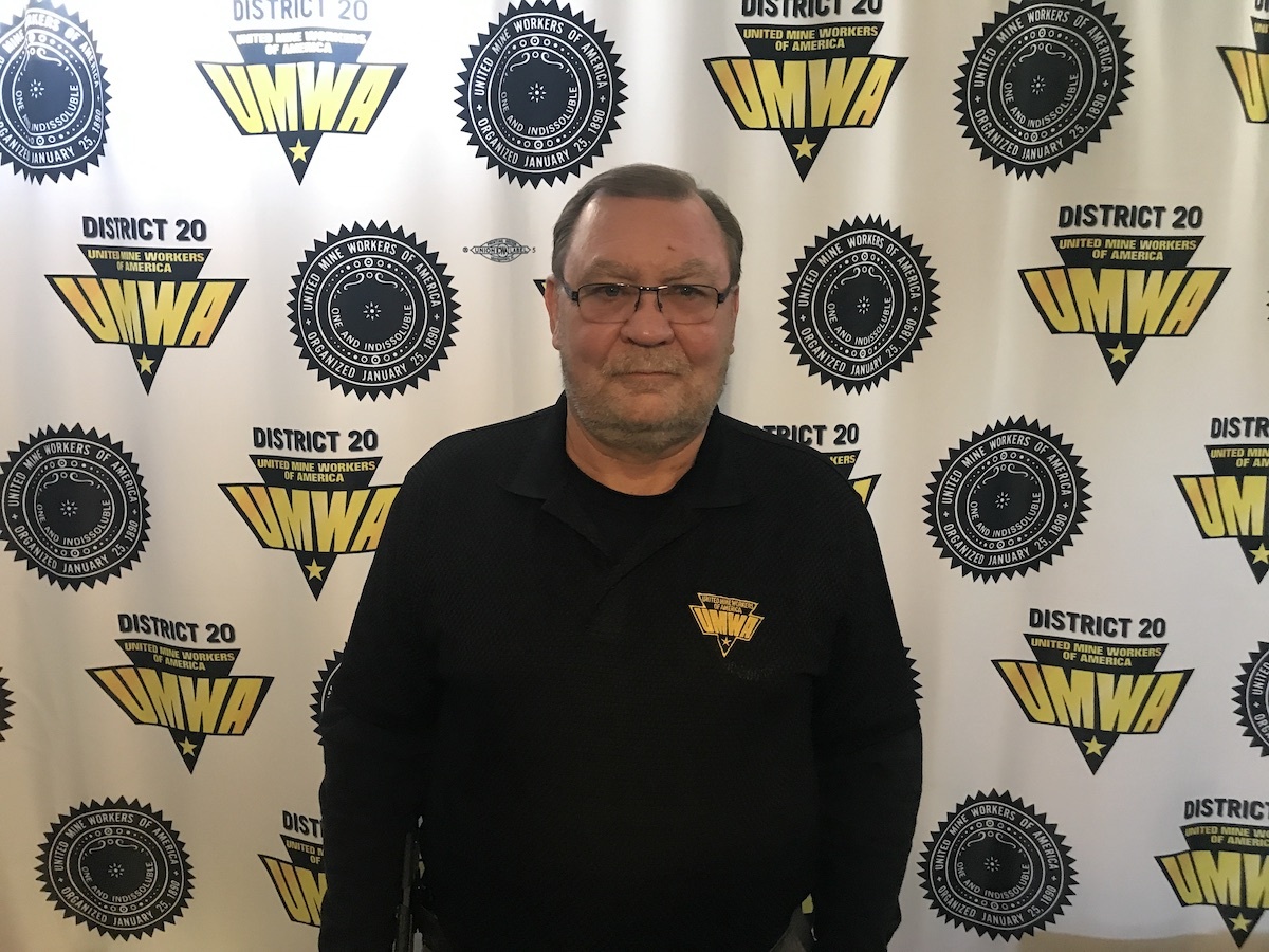 Larry Spencer stands in front of a UMWA logo backdrop
