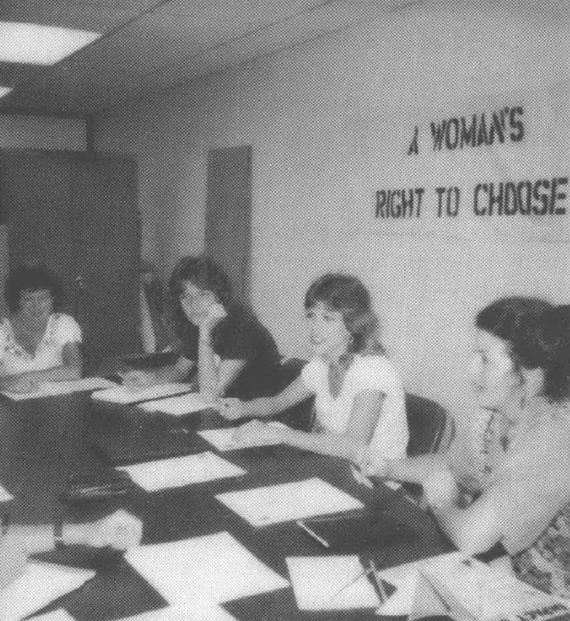Women at a table with a "A Woman's Right to Choose" banner above them