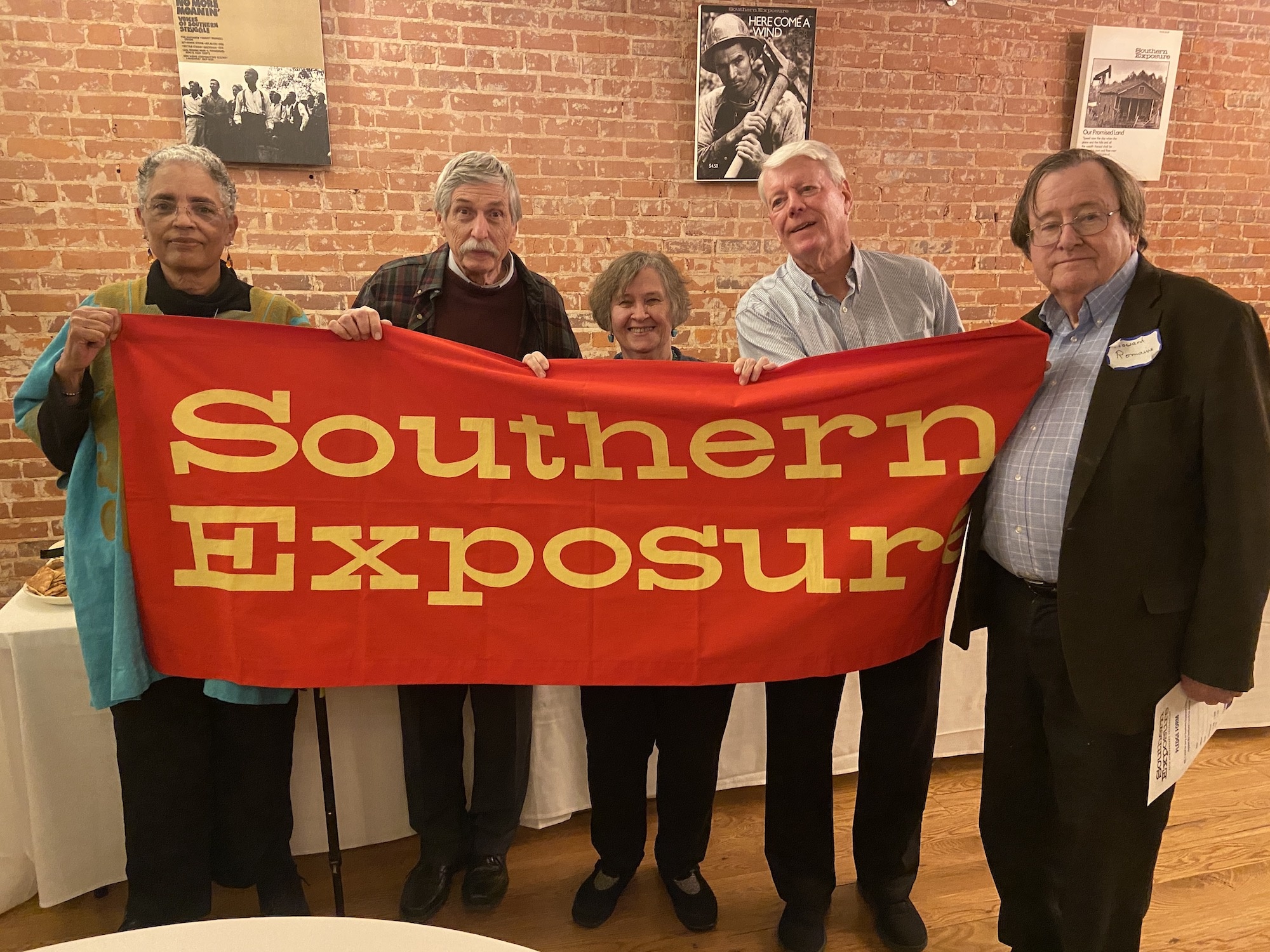 Five people holding up the Southern Exposure banner