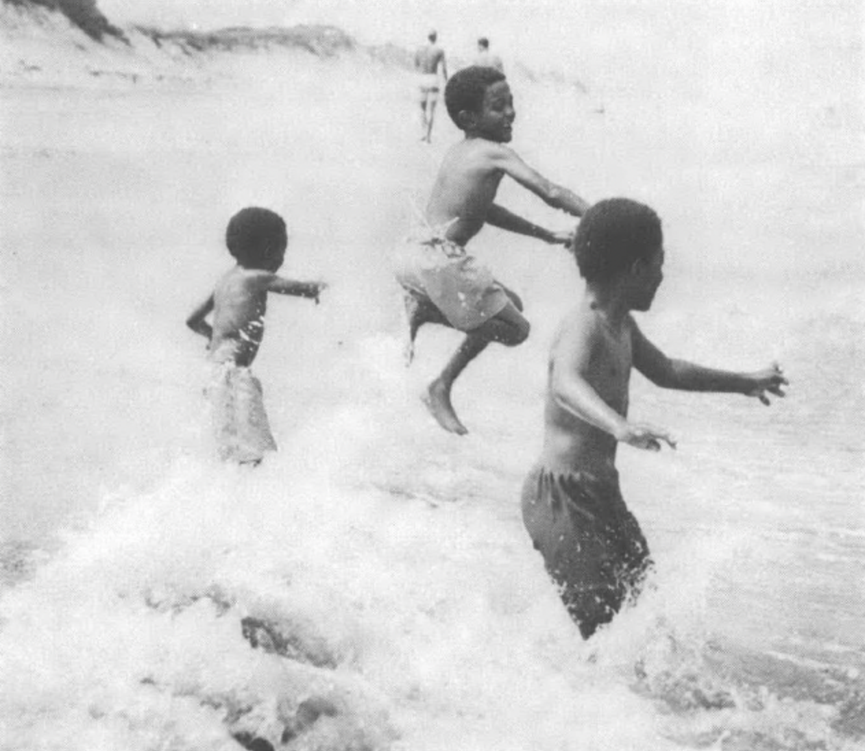Three young Black boys playing in water