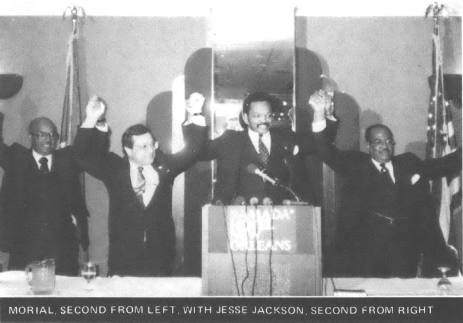 men holding and raising their hands, including Morial and Jesse Jackson