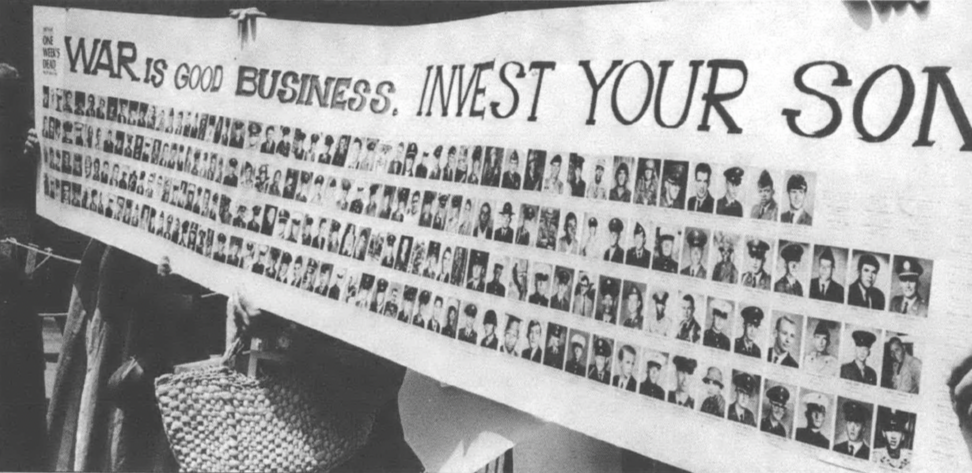 Banner reading "War is good business, invest your son" with multiple photos of enlisted men underneath