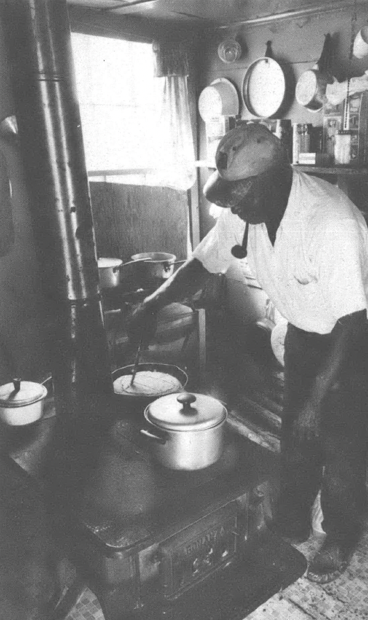 Black and white photo of man standing over buckets