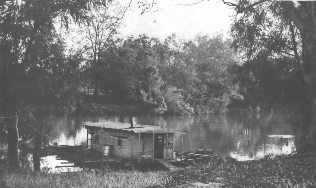 Black and white photo of houseboat on lake