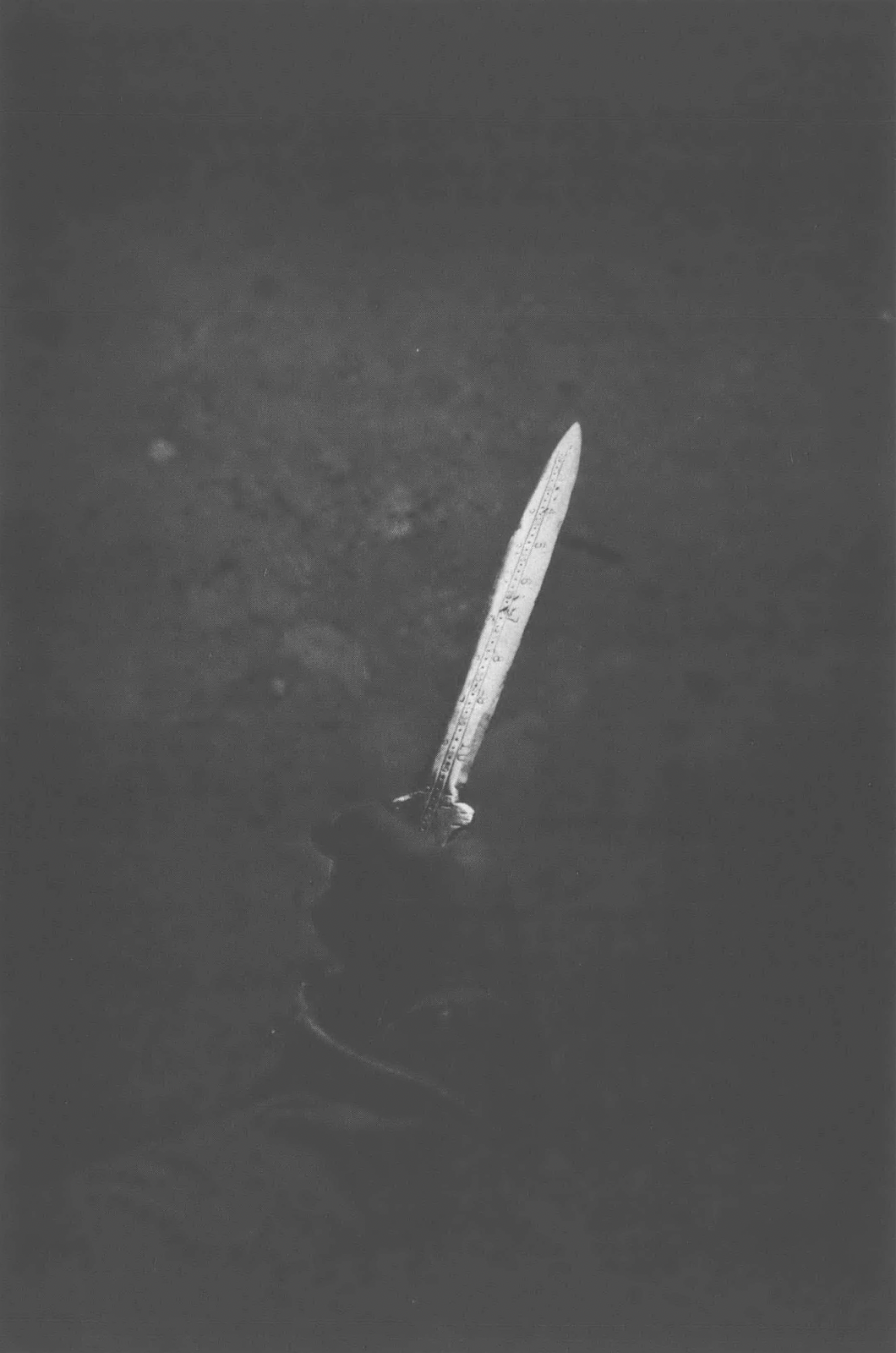 Black and white photo of knife against dark background