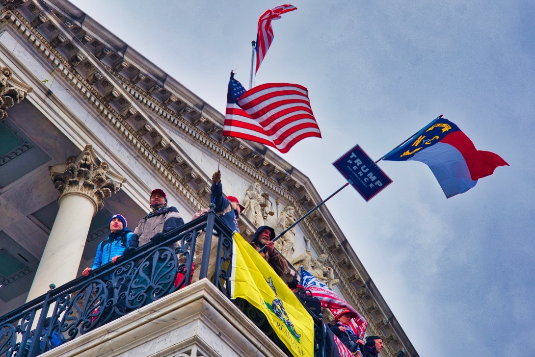 Rioters at the U.S. Capitol wave the American flag, the North Carolina state flag, and others on Jan. 6, 2021 